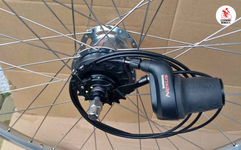 Koło rowerowe z piastą Shimano Nexus 3 na tle kartonu.